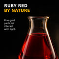 Ruby red colloidal gold liquid in clear glass illustrating how fine gold particles interact with light.