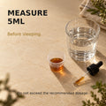 Graduated cup measuring 5ml of Lucid Dreaming herbal tincture before sleep.