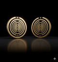 Two gold circular earrings with a spiral design on a black background