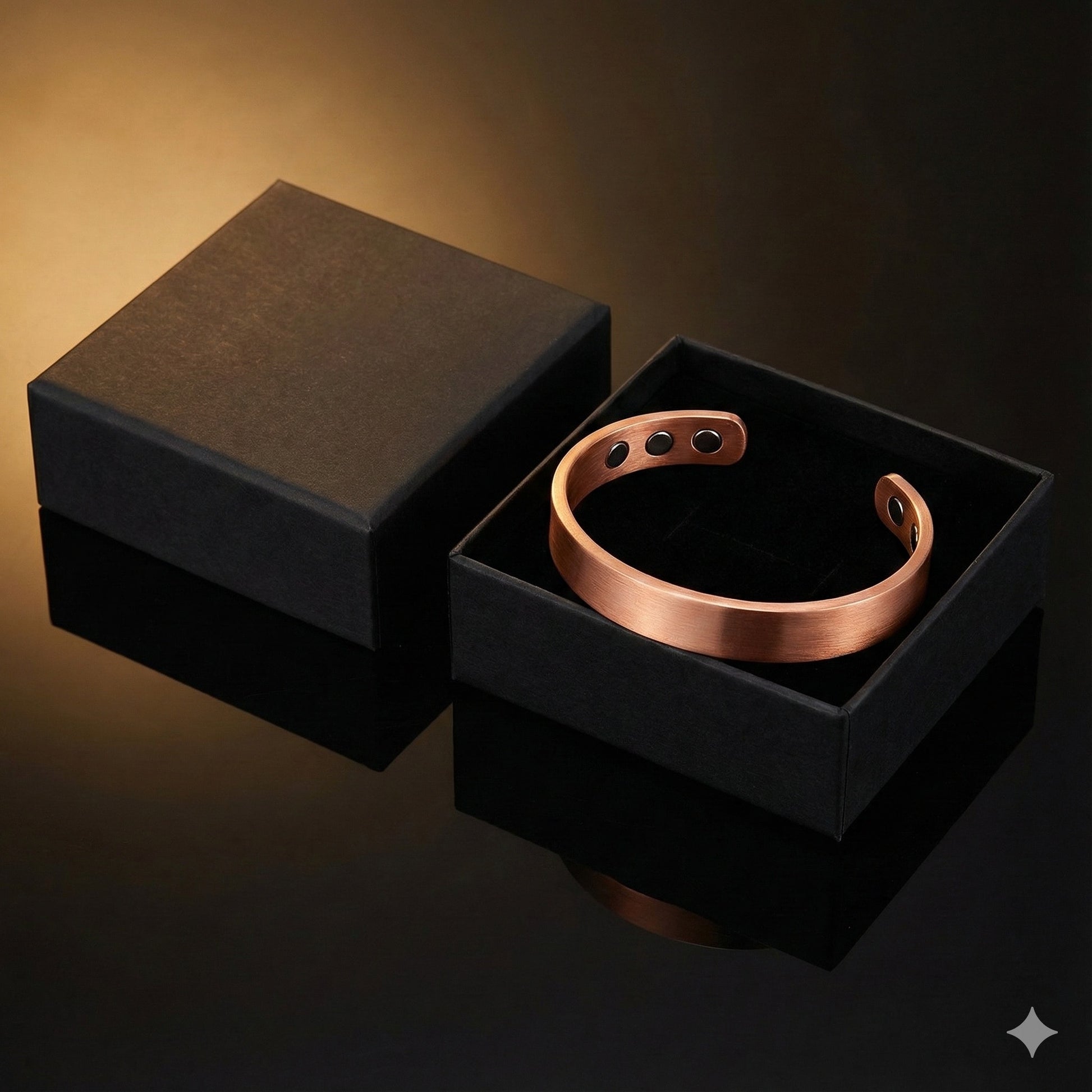 Rose gold bracelet in a black box on a reflective surface with a dark background