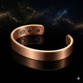 Copper bracelet with embedded magnets on a dark space-themed background