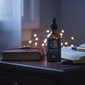 Bottle of Lush Organics tincture on a wooden surface with a notebook and pen in the background.