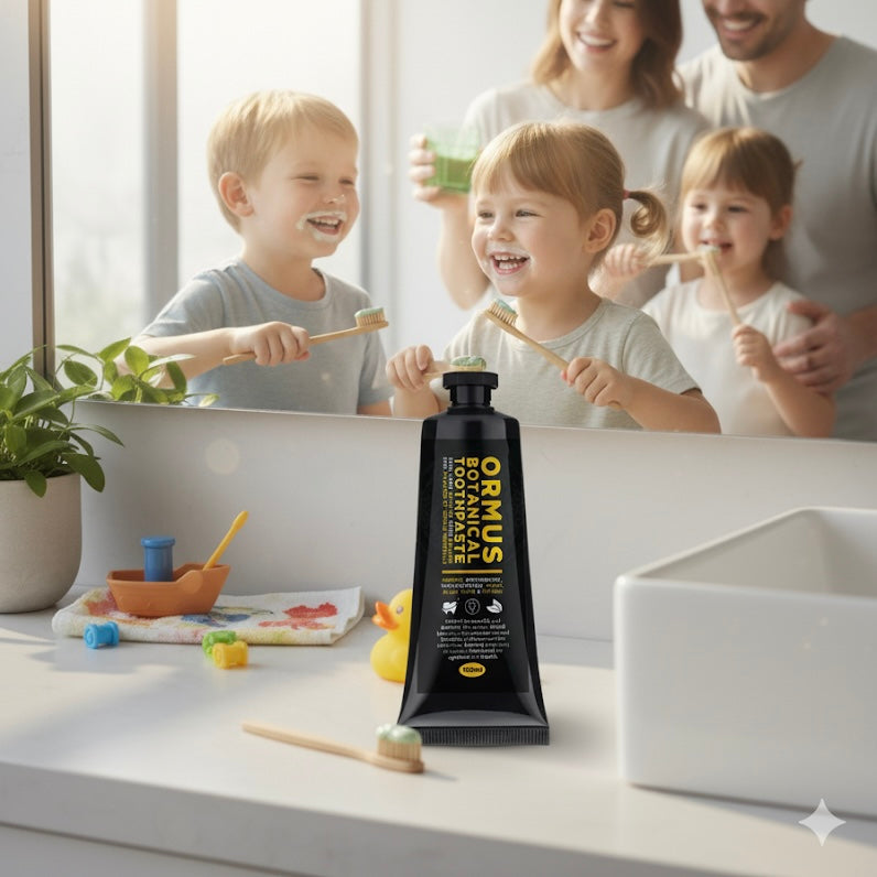 Family of four brushing teeth with a bottle of Ormus Fluoride free Botanical Toothpaste on a counter.