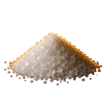 A small mound of coarse white crystalline powder of potassium, photographed on a glossy black surface with dramatic warm lighting highlighting the texture and edges.