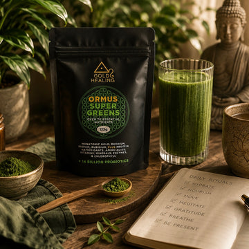 Gold Healing Ormus Super Greens displayed in a premium wellness setting with green powder, smoothie glass and elevated lifestyle styling