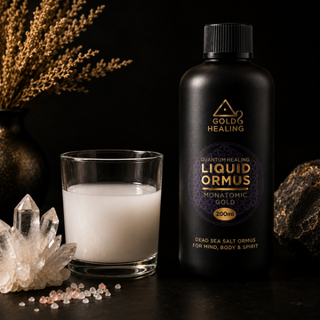 Gold Healing ORMUS Liquid Monatomic Gold 200ml beside a glass of white mineral liquid with crystal stones and natural wellness setting