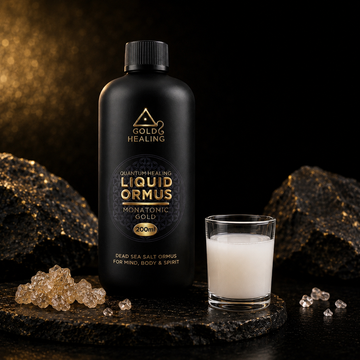 Gold Healing ORMUS Liquid in a Miron violet glass bottle beside a small glass of white ORMUS liquid with Dead Sea mineral crystals.